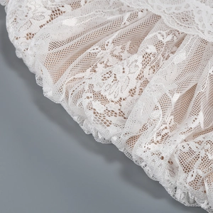 Gros plan sur un élégant tissu en dentelle blanche avec plis superposés et détails en maille