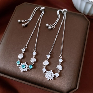 Detail of adjustable zircon flower charm bracelet with blue gemstone on velvet