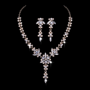 Macro detail of bridal crystal flower necklace and earrings set in golden finish