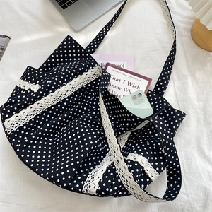 Detailed close-up of polka dot canvas tote with lace trim and daily essentials