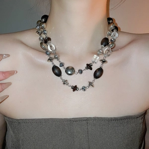 Detail of vintage double-layer necklace with wood beads, crystal and silver geometric elements