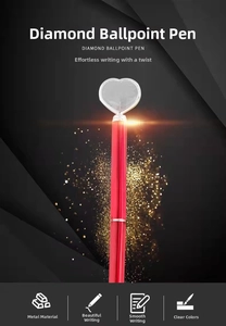Macro shot of red metal ballpoint pen featuring a large heart-shaped diamond crystal on top