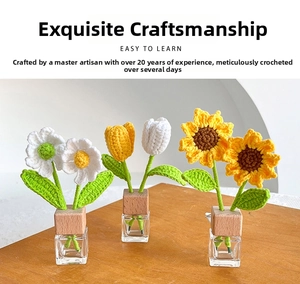 Close-up of handmade crochet sunflower and tulip with wooden base in glass vase