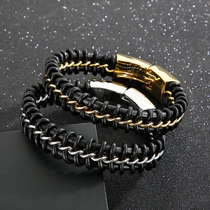 Detail of woven leather bracelets with gold and silver metal chains and magnetic clasps
