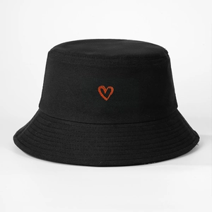 Close-up of red heart embroidery on a black cotton canvas bucket hat detail