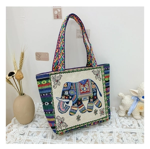 Detail of bohemian tote bag with elephant embroidery and colorful woven strap texture