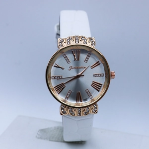Detail of rose gold crown watch featuring crystal accents and a white leather strap
