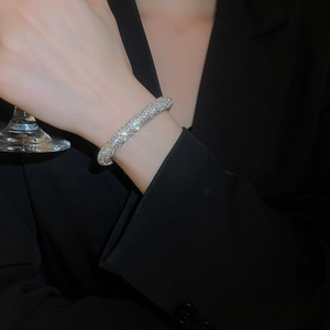 Close-up of sparkling silver-toned rhinestone pavé bangle on a woman's wrist