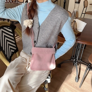 Détail du sac à bandoulière en daim rose avec bordure en peluche blanche pour l'automne
