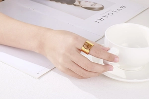 Close-up of golden wide tree of life cutout ring worn on hand with lifestyle background
