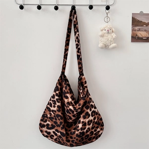 Detail view of large leopard print canvas tote bag with wide strap hanging on wall