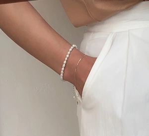 Detailed view of layered 925 sterling silver bracelet with elegant oval white pearls