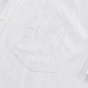 Close-up of white linen shirt showing chest pocket detail and natural fabric texture