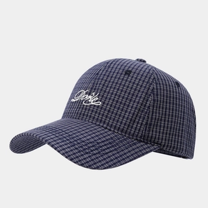 Detailed embroidery of cursive white letters on a navy blue checkered baseball cap