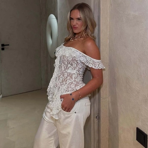 Detail of off-the-shoulder white lace top with lace-up ribbon and irregular hem stitching