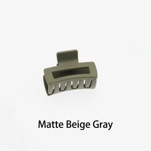 Detail of a matte beige grey hollow rectangular hair claw clip with a frosted finish