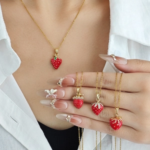 Joli collier avec pendentif fraise rouge, chaîne dorée et breloques fraise en émail