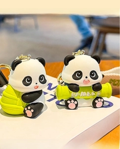 Close-up of cute resin panda keychain with green bamboo detail and golden metal ring