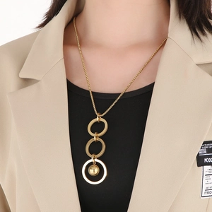 Detail of gold triple-interlocked circles with a round bead pendant on a stylish chain