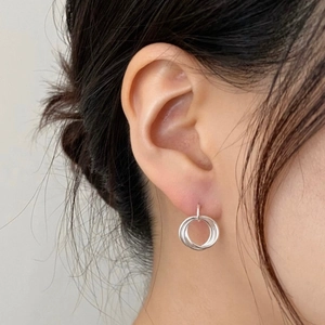 Detail view of triple interlocking hoop earrings in S925 sterling silver worn by a model
