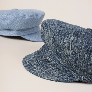 Close-up of textured denim newsboy caps showing detailed woven fabric and stitching