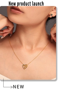 Détail du collier pendentif cœur doré et boucles d'oreilles créoles aux gemmes colorées