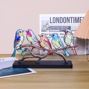 Stained glass style bird figurines on a branch with a sleek black desktop base