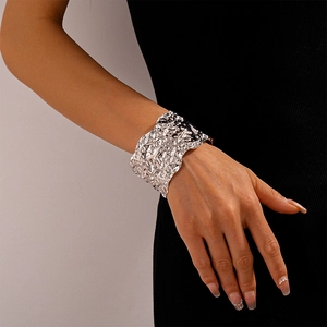 Detail of silver textured cuff bracelet with irregular wrinkled pattern on model wrist
