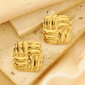 Golden square earrings with woven texture on beige stone and champagne silk background