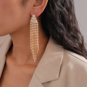 Close-up of model wearing gold long tassel earrings with sparkling cubic zirconia stones
