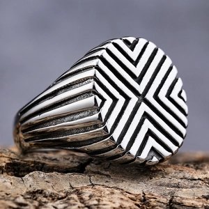 Men's geometric stainless steel ring with X-shape radial lines on textured wood base