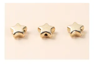 Macro shot of three gold-plated star-shaped beads with precision drilled holes for DIY jewelry