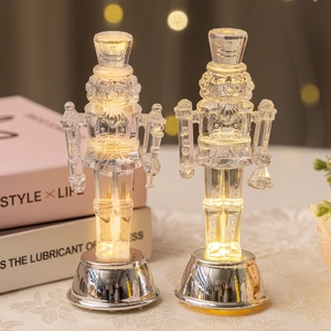 Pair of clear LED Nutcracker soldier figures with warm lights on silver metal bases