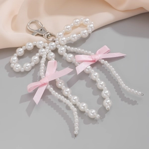 Detail of white pearl beads and pink ribbon bow pendant with a silver lobster clasp