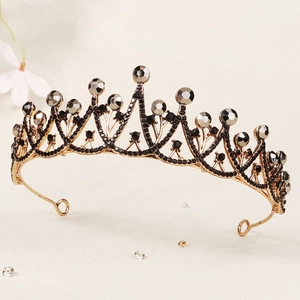 Detailed macro view of vintage gold alloy crown featuring black rhinestones and smoky crystals