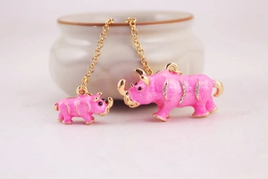 Detailed close-up of pink enamel rhino keychains with gold plating and rhinestones