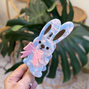 Close-up of blue marble acetate bunny hair claw clip with a pink bow decoration