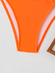 Close-up of bright orange bikini bottoms showing high-elastic quick-dry fabric texture