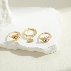 Three gold vintage rings featuring geometric devil eye design with blue zircon stones
