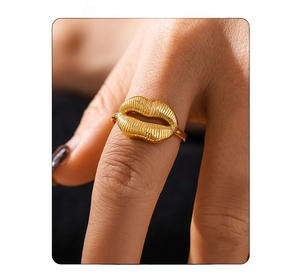 Close-up of golden lip-shaped ring on model finger with sleek PVD plated metal texture