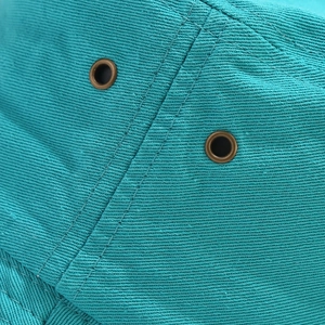 Teal cotton bucket hat with breathable metal eyelets and reinforced stitching detail