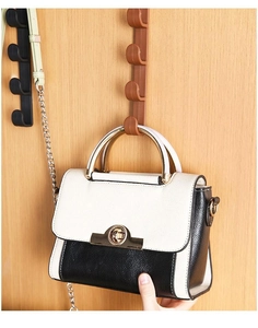 Close-up of vertical over-the-door hooks for bags and hats in brown and black finishes