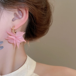 Detail of pink acrylic flower earrings with layered petals and small central rhinestones