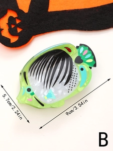Detail view of a green fish-shaped hair claw clip with size dimensions 9cm x 5.7cm