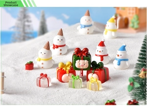 Detailed close-up of resin snowman figurines and pig-themed gift box in snowy scene