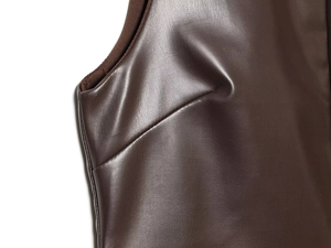 Vista macro dettagliata della trama in pelle marrone scuro e cuciture della tuta donna