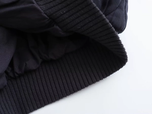 Dettaglio dei polsini a costine e fodera imbottita di un bomber nero lavato in cotone