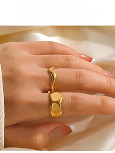 Polished gold irregular wave ring on female finger with satin fabric background