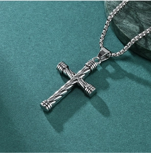 Detail of vintage twisted texture on a stainless steel cross pendant for men