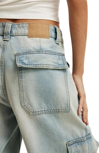 Detail view of high-waisted washed denim cargo pants with large side pockets for women